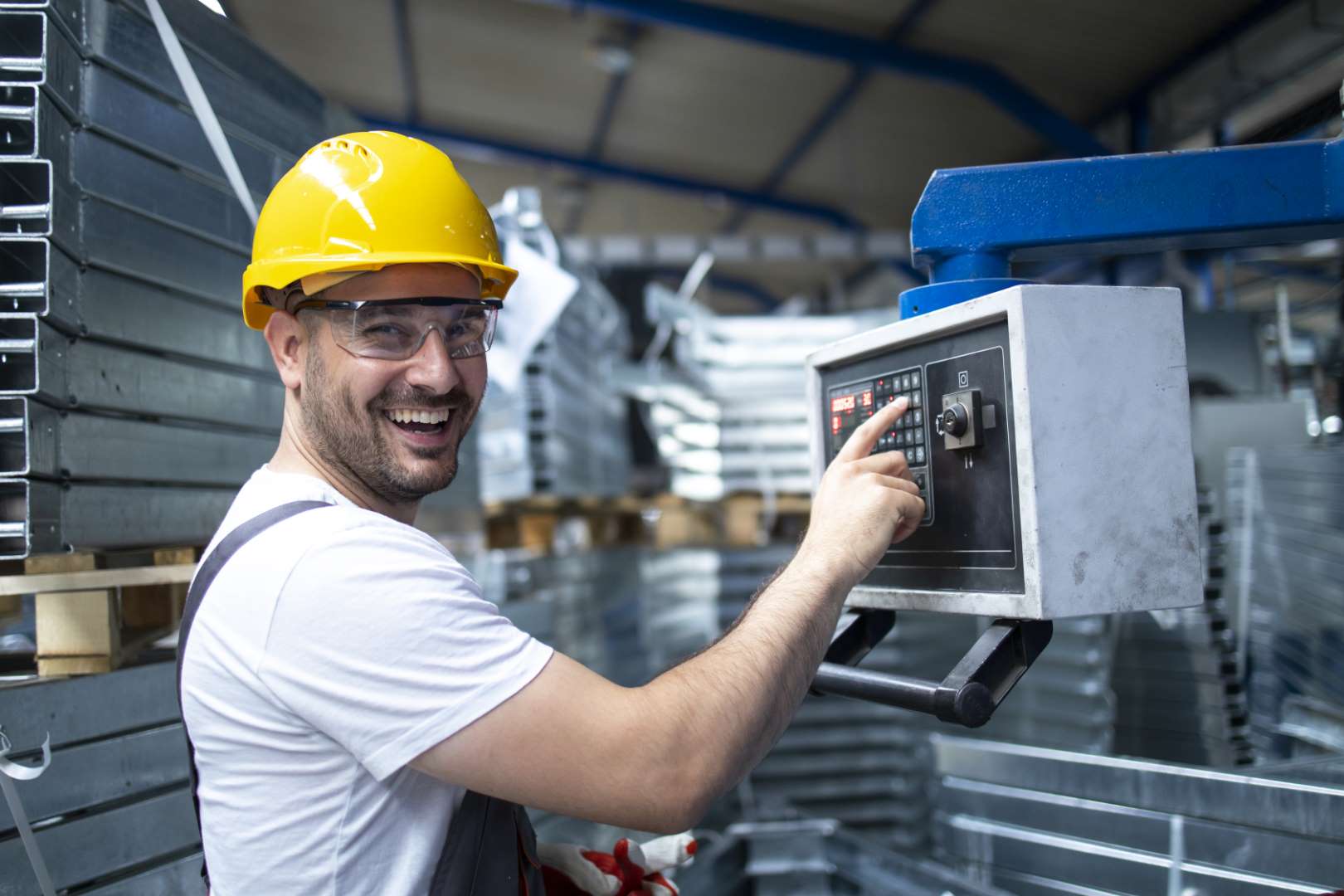 portrait factory worker operating industrial machine setting parameters computer